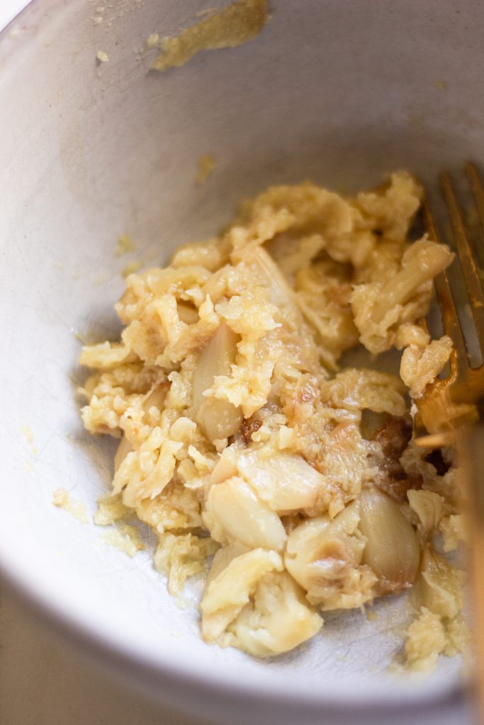 roasted garlic mashed into a paste in a bowl