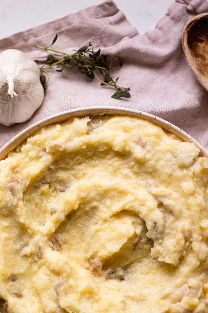 close up of half of the bowl of roasted garlic mashed potatoes without extra butter on top