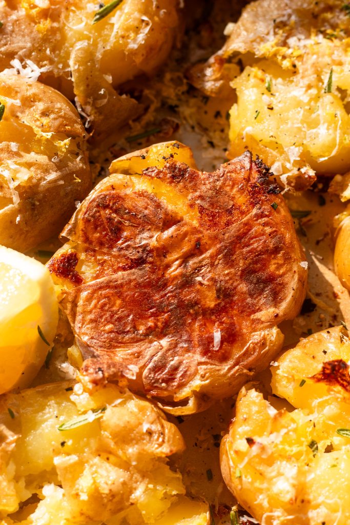 close up photo of crispy bottom of smashed potato on pan