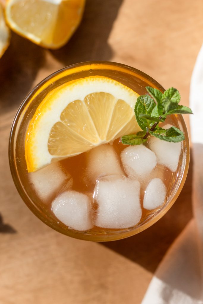 overhead photo of garnished arnold palmer with lemon slice and sprig of mint