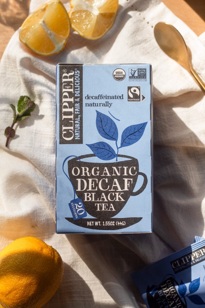 box of Clipper Organic Decaf Black tea surrounded by sliced lemons